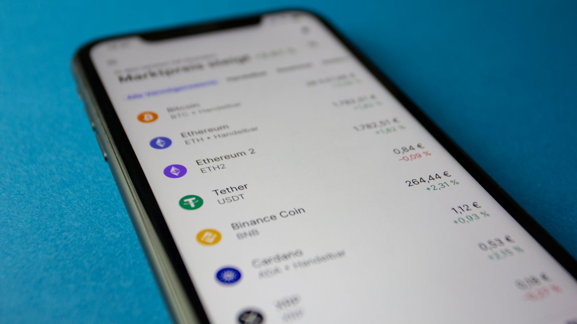Ilustrasi: Close-up photo of a smartphone displaying cryptocurrency market data with price listings.
