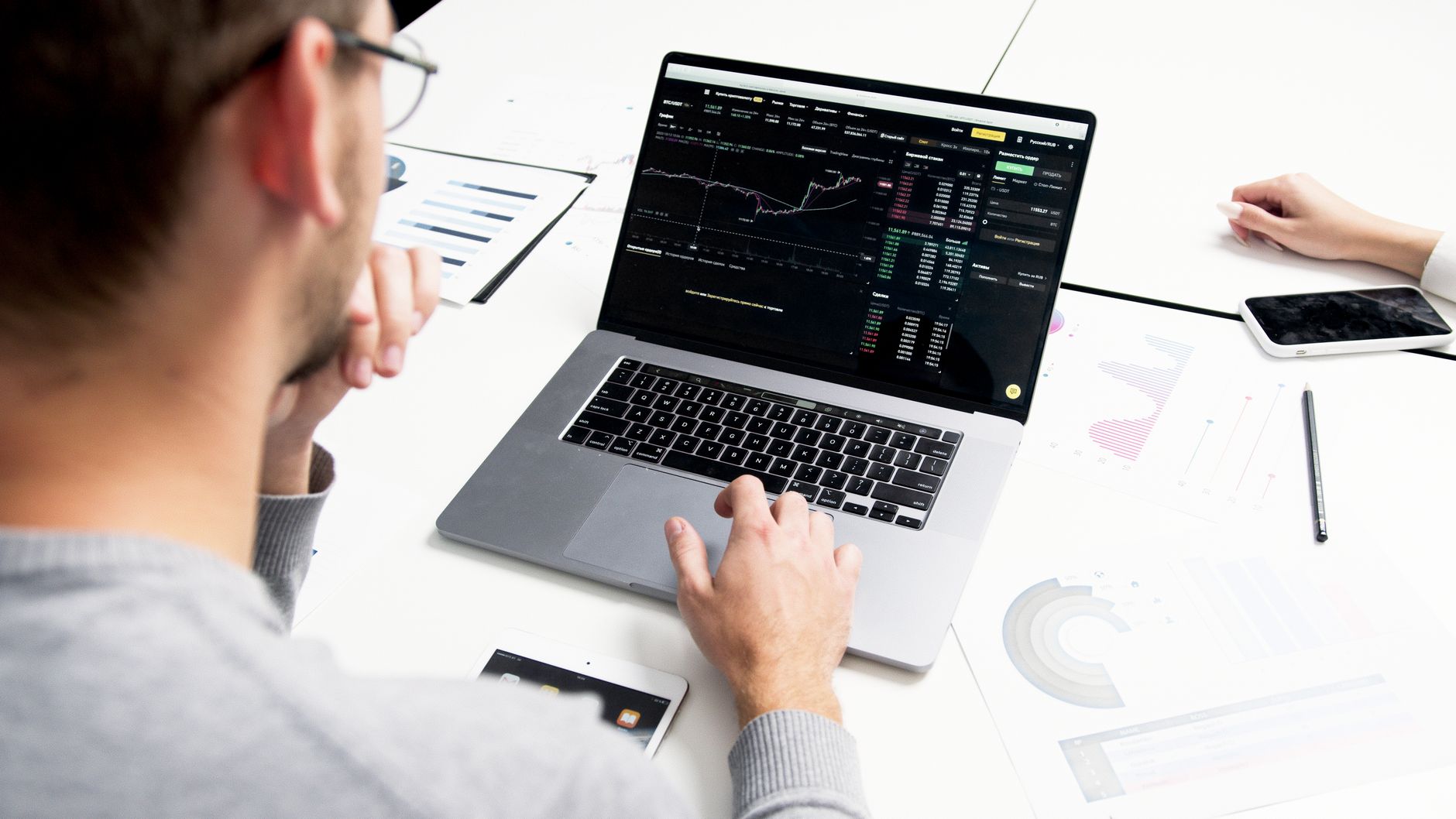 Ilustrasi: Business professional analyzing stock market data on a laptop for investment insights.