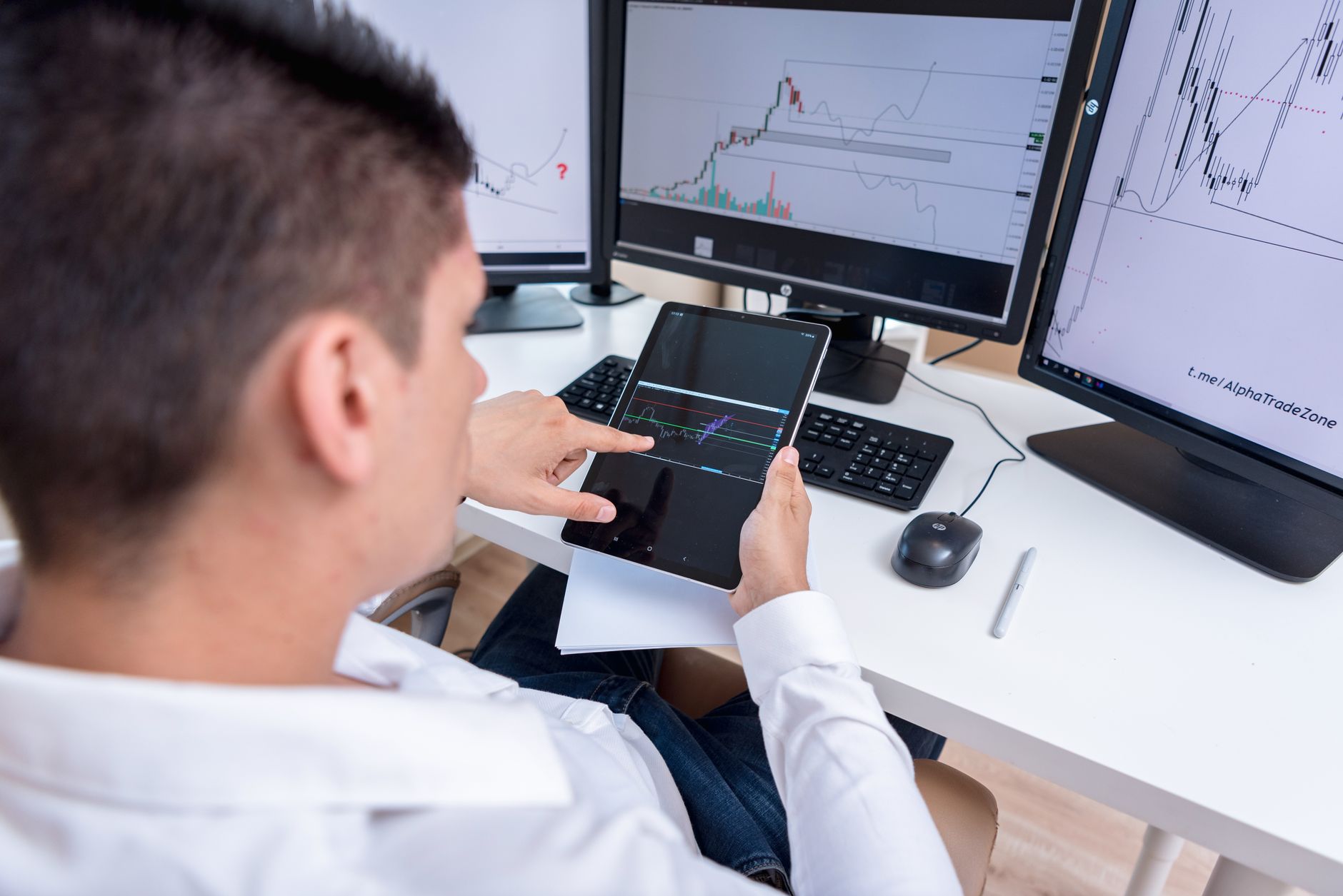 Ilustrasi: A stock trader analyzing cryptocurrency charts on multiple monitors and a tablet.